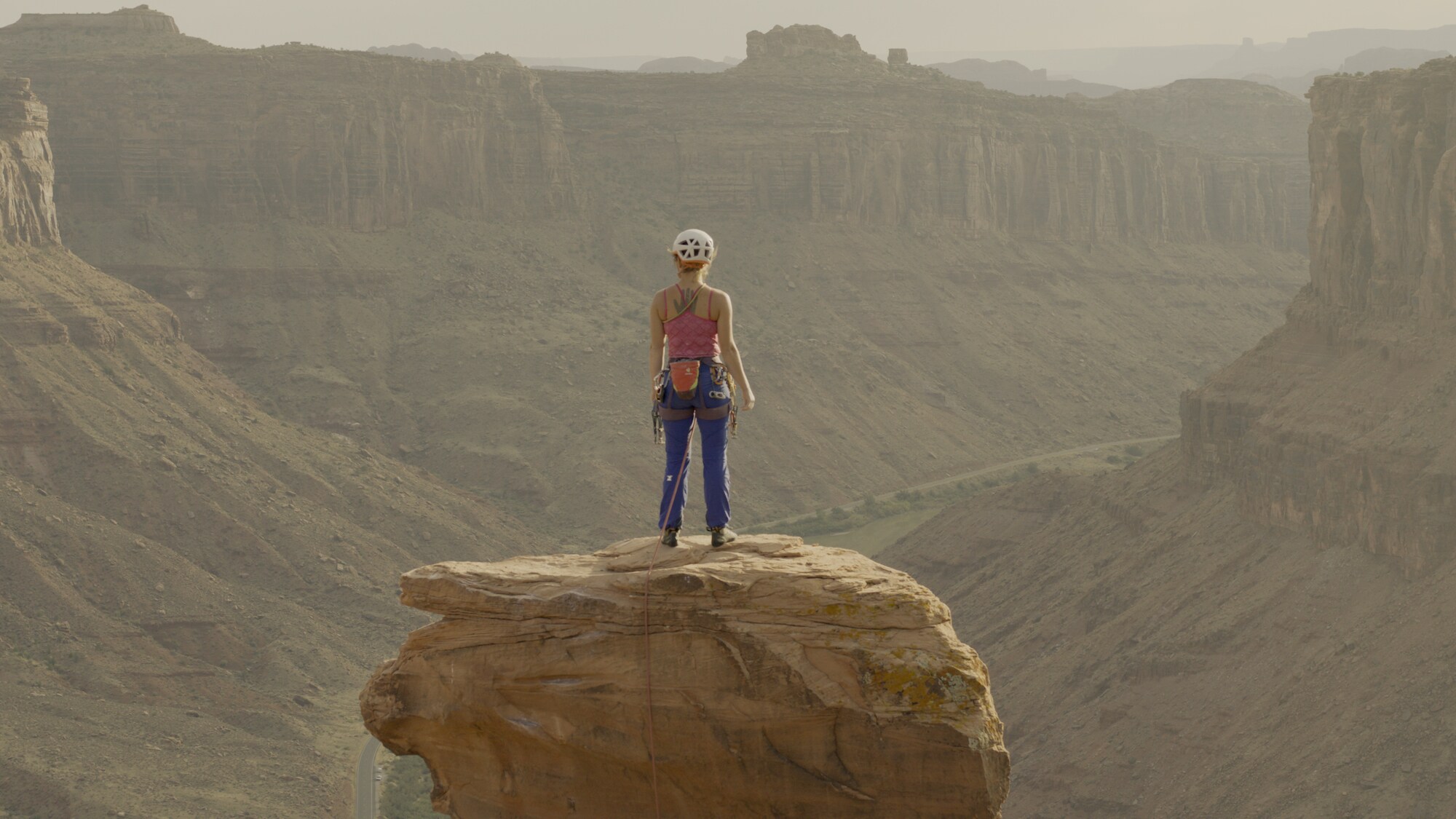 Faith Dickey looks out to the scenery after walking across on a slackline.  (National Geographic for Disney+)