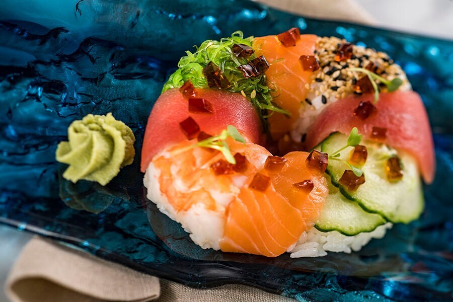 Image of sushi donut with a dollop of wasabi next to it