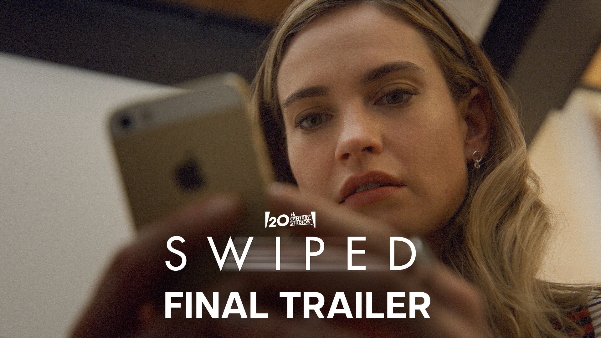 Image of Whitney Wolfe, played by Lily James, staring at a mobile phone she's holding, from the 20th Century Studios movie "Swiped", debuting exclusively in the US on Hulu September 19.