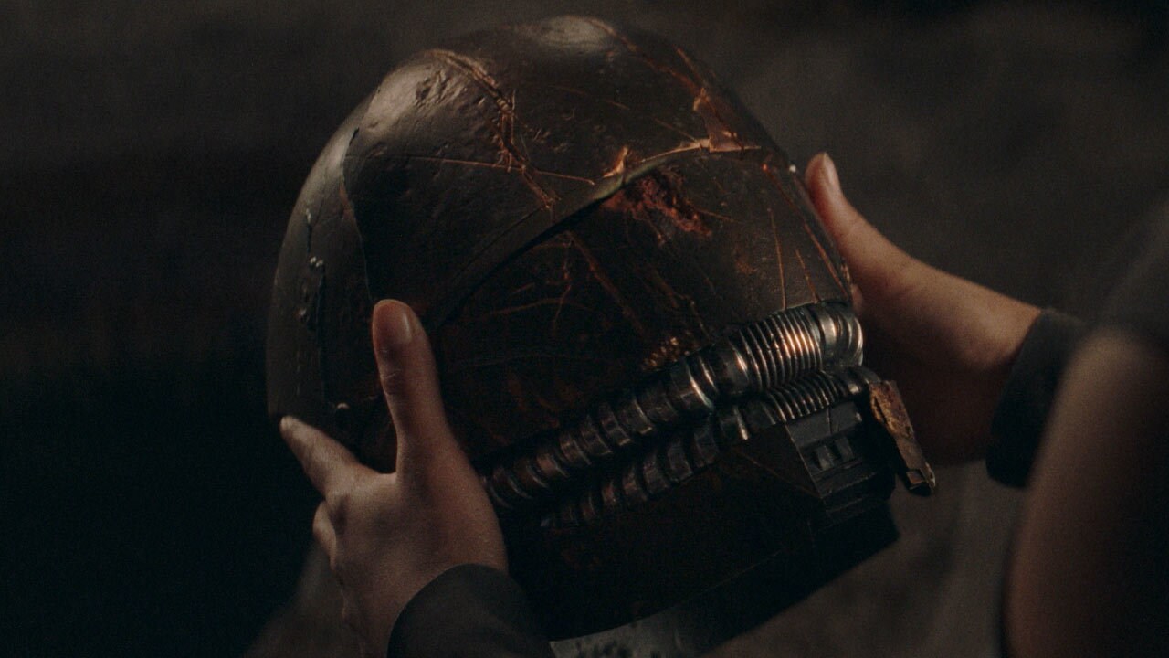 Osha holding the Stranger's helmet.