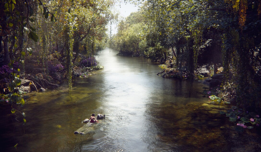 Mowgli (Neel Sethi) & Baloo (Bill Murray) floating down a river in "The Jungle Book"