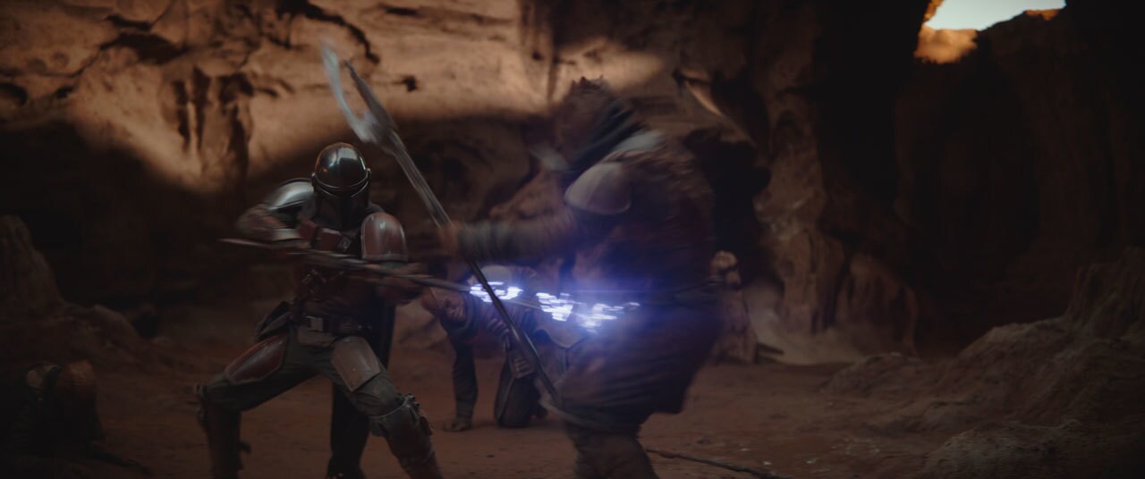 Three Trandoshan bounty hunters emerge from the shadows. They have the Mandalorian and the Child ...