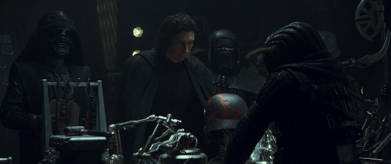 Skilled hands piece together Kylo Ren's shattered helmet as the Knights of Ren stand by silently....