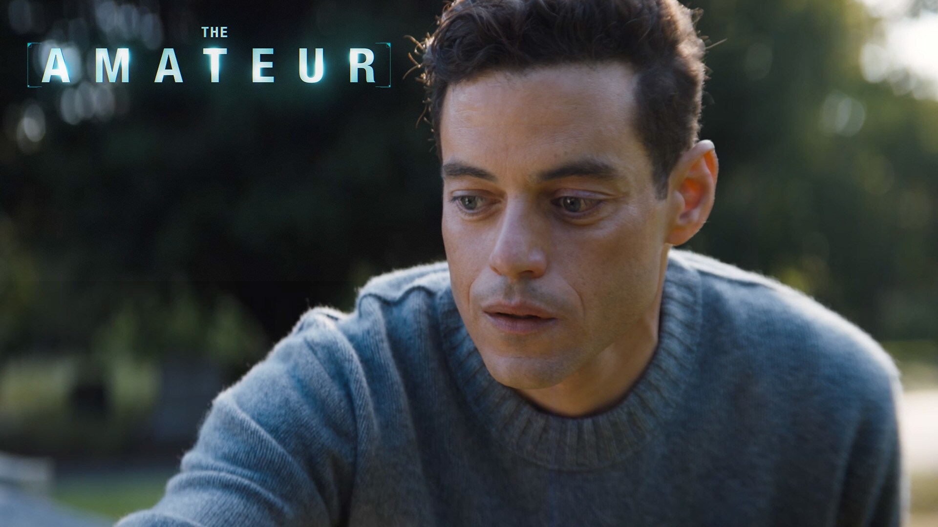 Still image of Charlie Heller (actor Rami Malek) looking off into the distance with a concerned look. From the 20th Century Studios movie, "The Amateur."