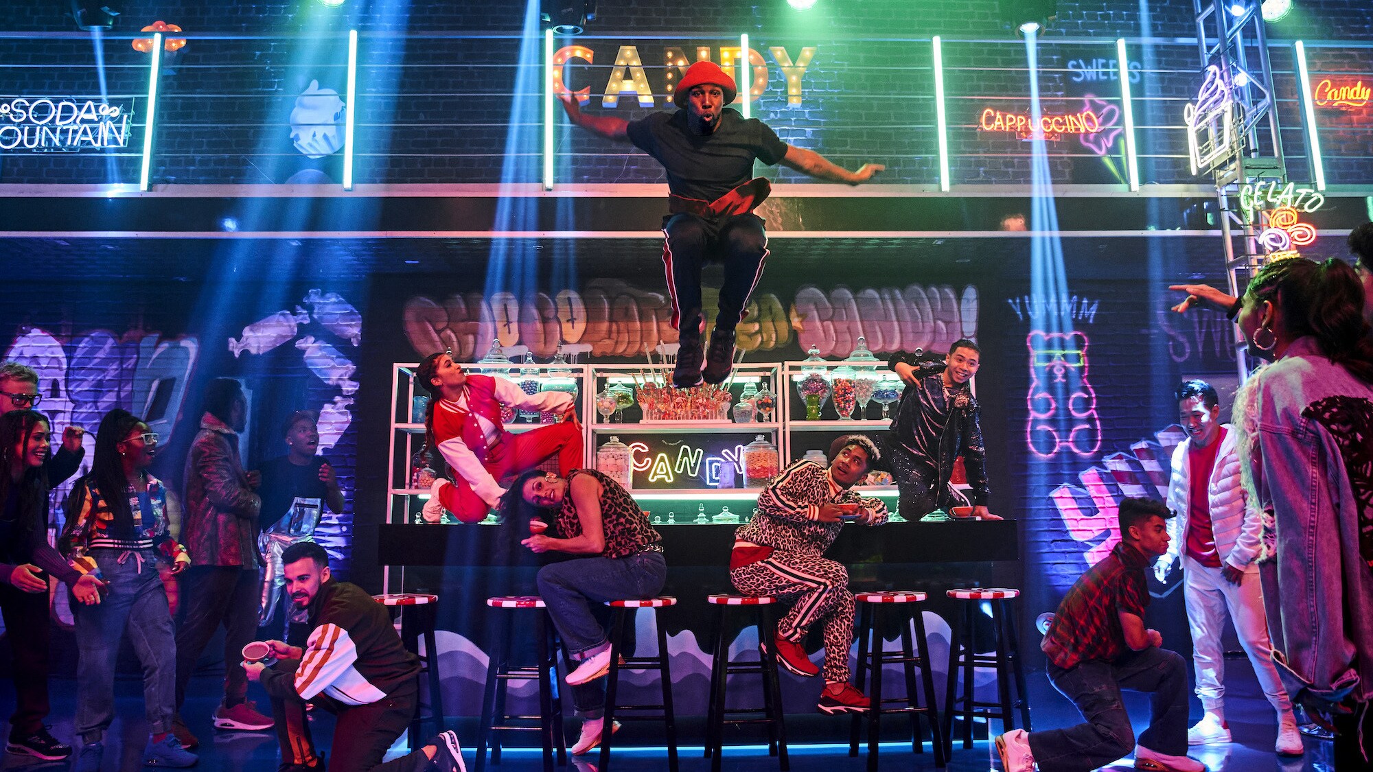 Dad, played by Stephen "tWitch" Boss, jumps off the candy bar in the Land of Sweets in Disney's The Hip Hop Nutcracker. (Photo credit: Disney/Ser Baffo)