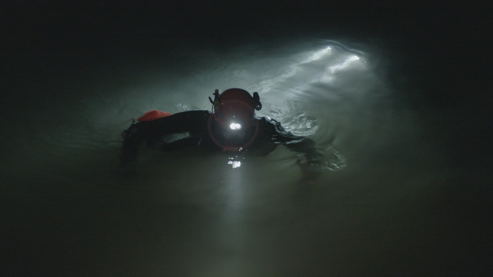 Cave diver emerges from water.  THE RESCUE chronicles the 2018 rescue of 12 Thai boys and their soccer coach, trapped deep inside a flooded cave. E. Chai Vasarhelyi and Jimmy Chin reveal the perilous world of cave diving, bravery of the rescuers, and dedication of a community that made great sacrifices to save these young boys. (Credit: National Geographic)
