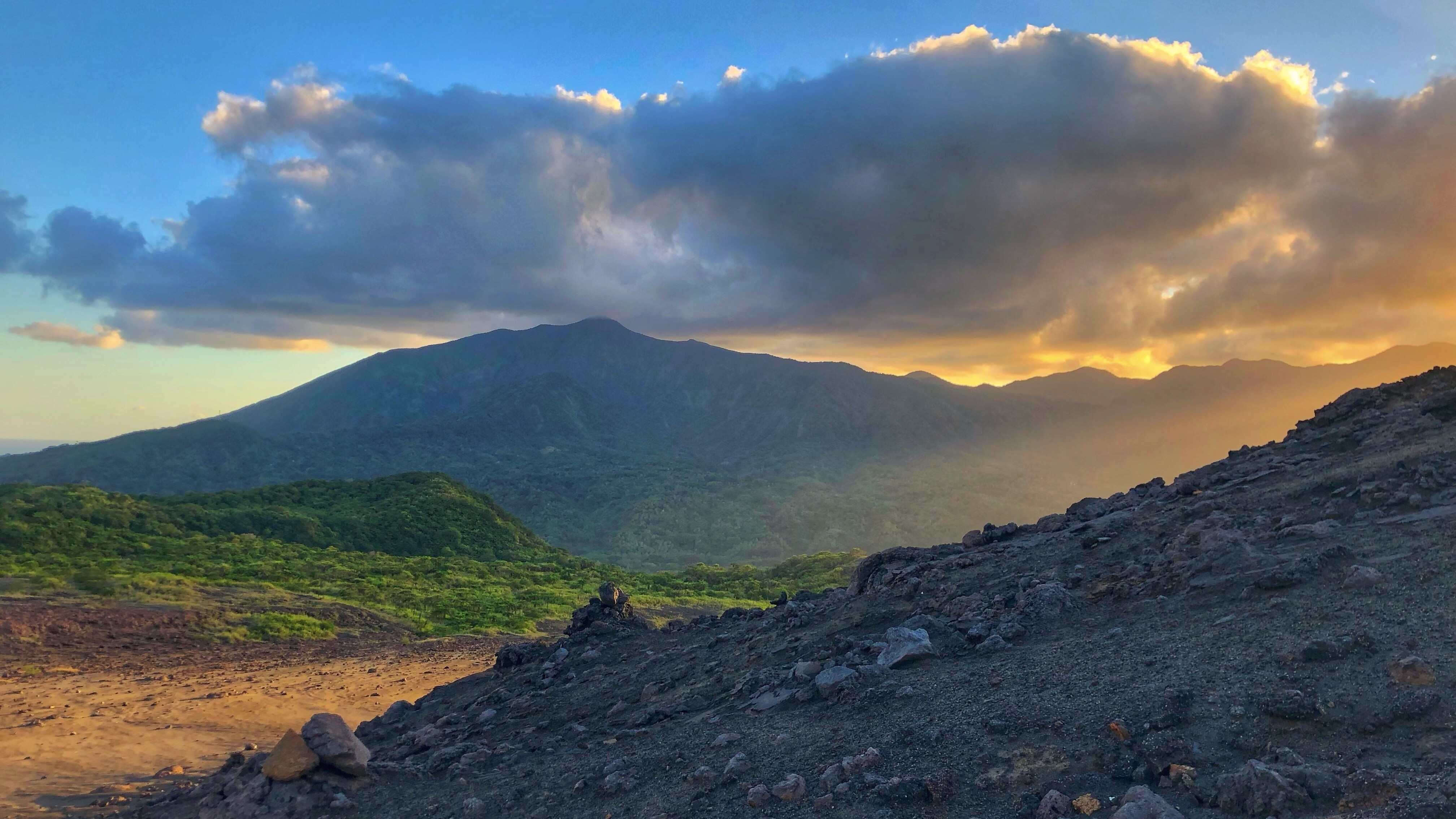 The sun breaks through, shining on the dividing line of life - the nutrient rich ash from the volcano can both take life and also create it. (photo credit:National Geographic for Disney+/Brendan McGinty)