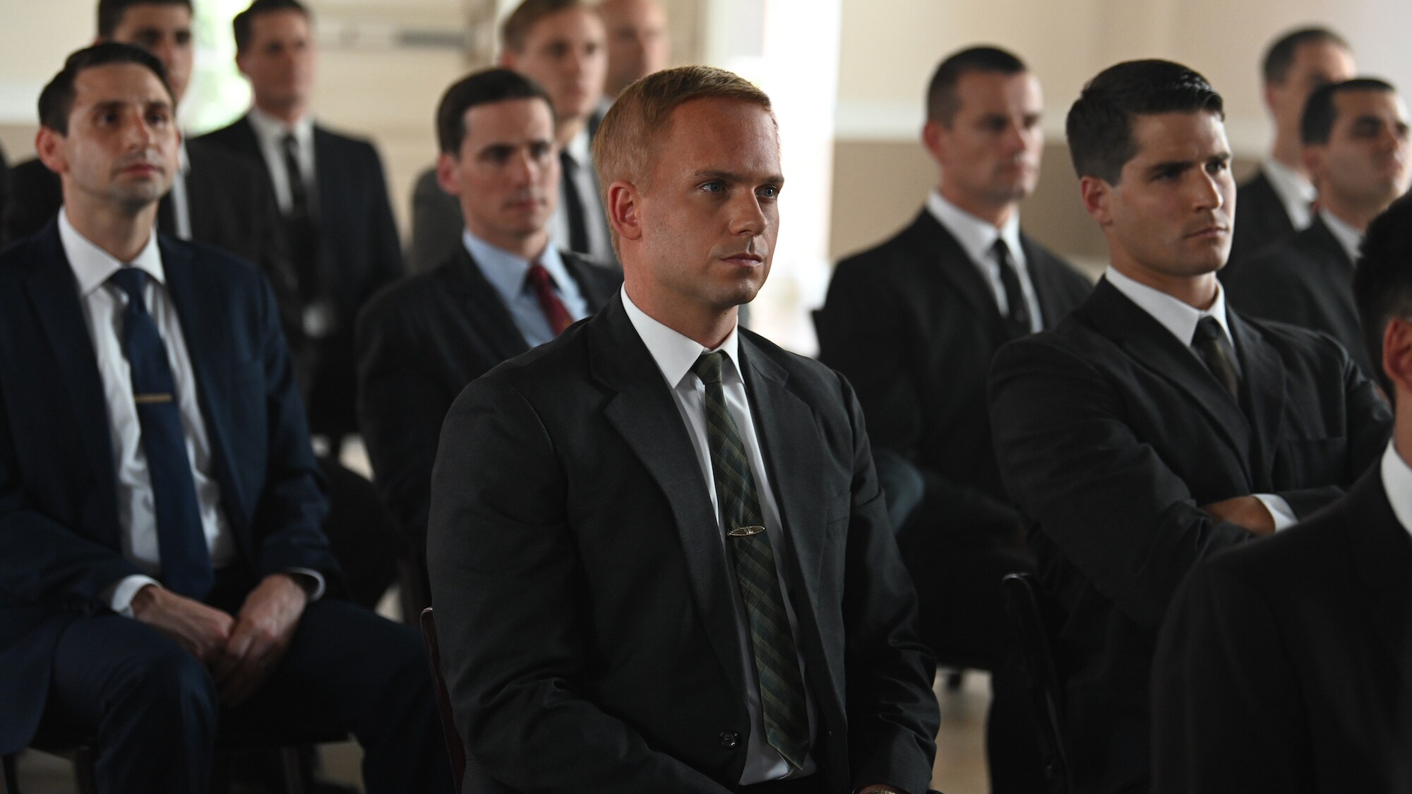 John Glenn (center) played by Patrick J. Adams attends a test pilot briefing at Langley Air Force Base in National Geographic's THE RIGHT STUFF streaming on Disney+. (Credit: National Geographic/Gene Page)