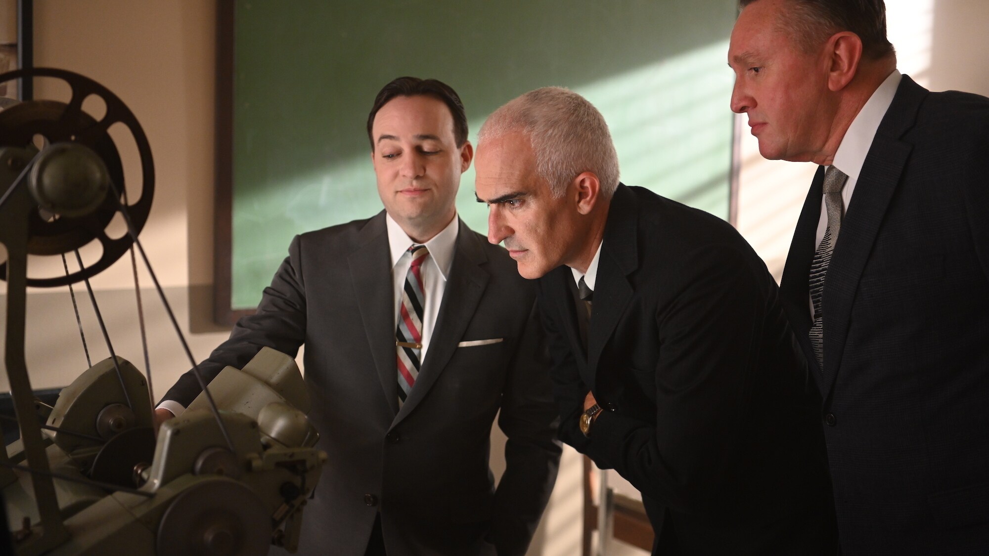 L to R: John "Shorty" Powers played by Danny Strong, Bob Gilruth played by Patrick Fischler and T. Keith Glennan Administrator of NASA played by Holland Hayes review press conference footage of the seven Mercury astronauts in National Geographic's THE RIG