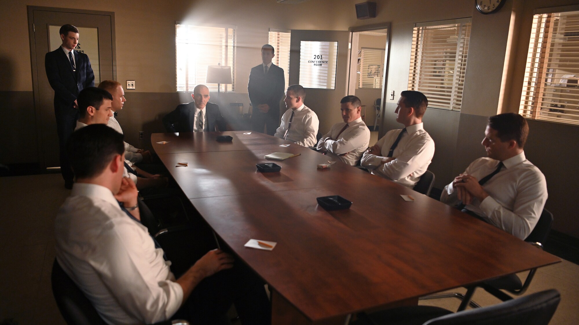 Glynn Lunney (back left) played by Jackson Pace and Chris Kraft (back right) played by Eric Ladin stand by as Bob Gilruth played by Patrick Fischler instructs the Mercury Seven to cast their peer vote which will determine the flight order of the first three astronauts in National Geographic's THE RIGHT STUFF streaming on Disney+. (National Geographic/Gene Page)