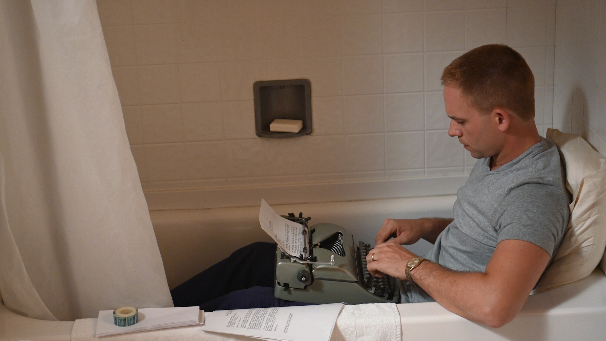 John Glenn, played by Patrick J. Adams, writes a letter in the tub to expose the questionable conduct of a fellow astronaut which could jeopardize the future of the space program in National Geographic's THE RIGHT STUFF streaming on Disney+. (National Geographic/Gene Page)