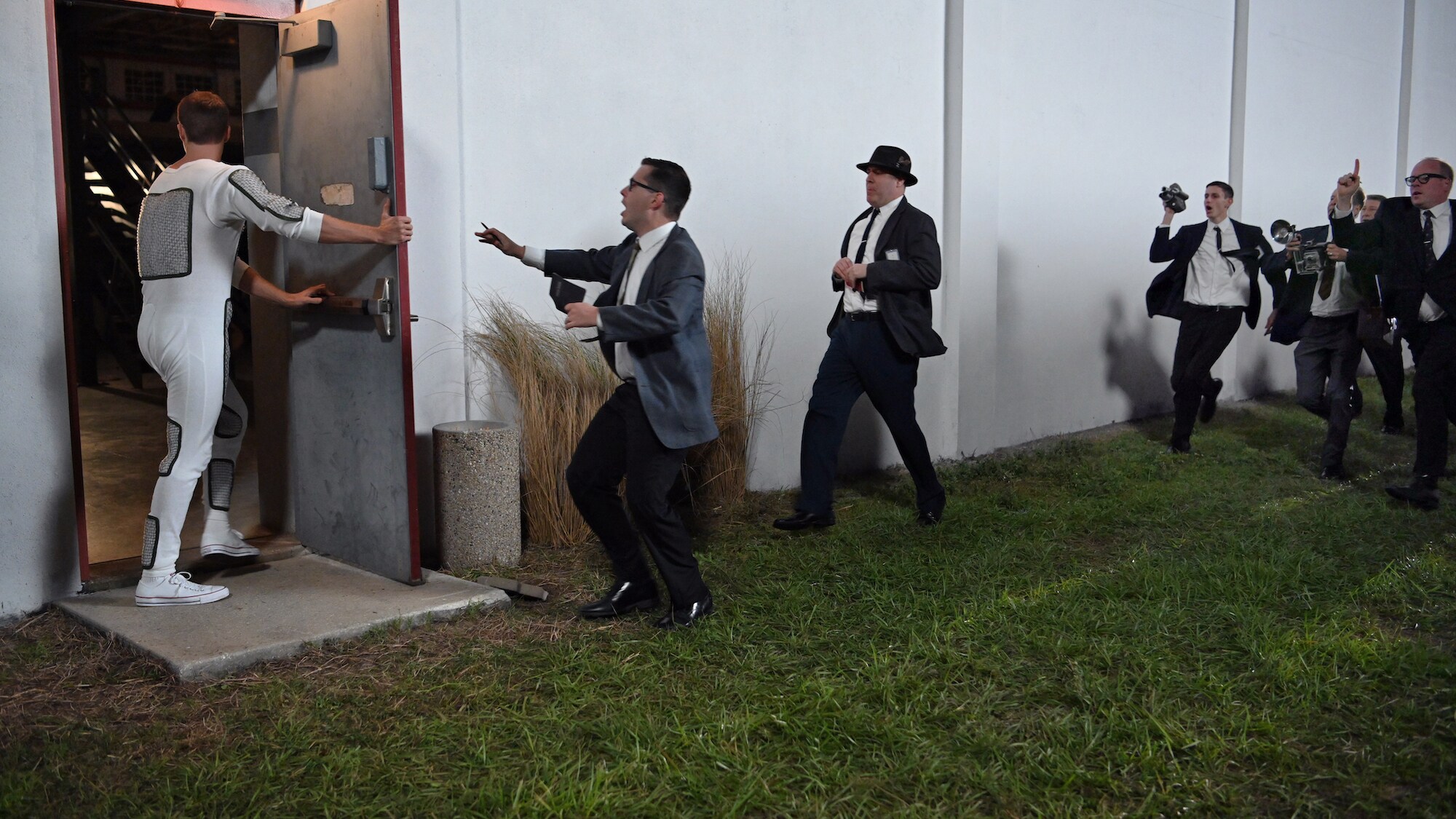 Alan Shepard (L) played by Jake McDorman runs from the press in National Geographic's THE RIGHT STUFF streaming on Disney+. (National Geographic/Gene Page)