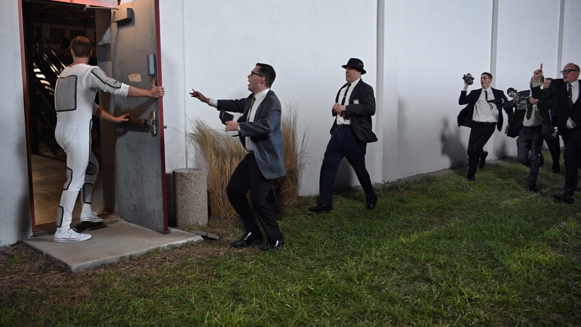 Alan Shepard (L) played by Jake McDorman runs from the press in National Geographic's THE RIGHT STUFF  streaming on Disney+. (National Geographic/Gene Page)