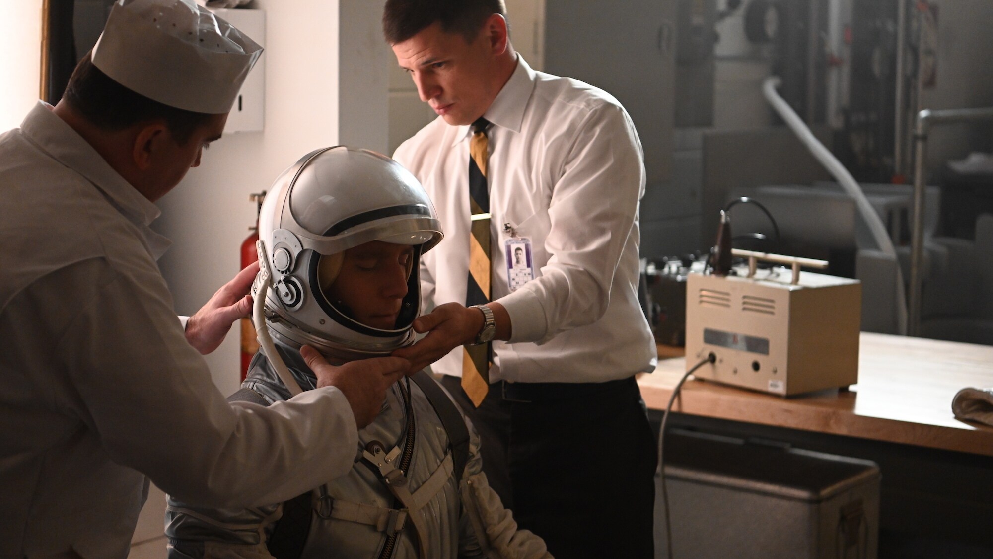 Gus Grissom (R) played Michael Trotter helps Alan Shepard (center) played by Jake McDorman with his space suit in National Geographic's THE RIGHT STUFF streaming on Disney+. (National Geographic/Gene Page)