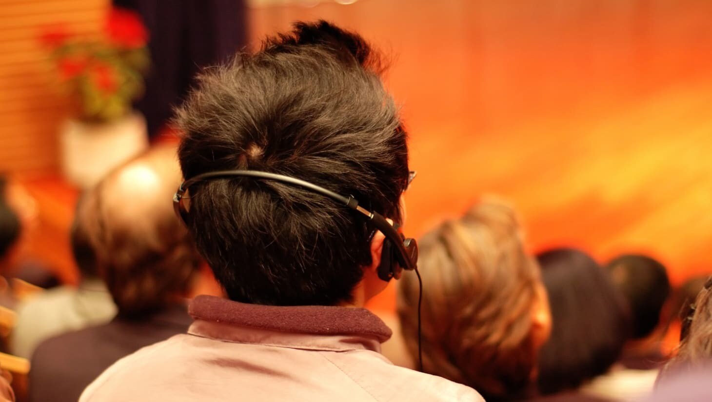 A member of the audience watching the performance with headphones.