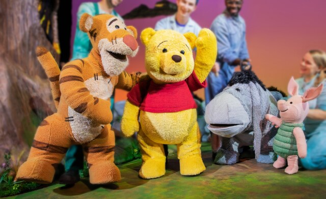 Winnie the Pooh, Tigger, Eeyore and Piglet puppets on stage.