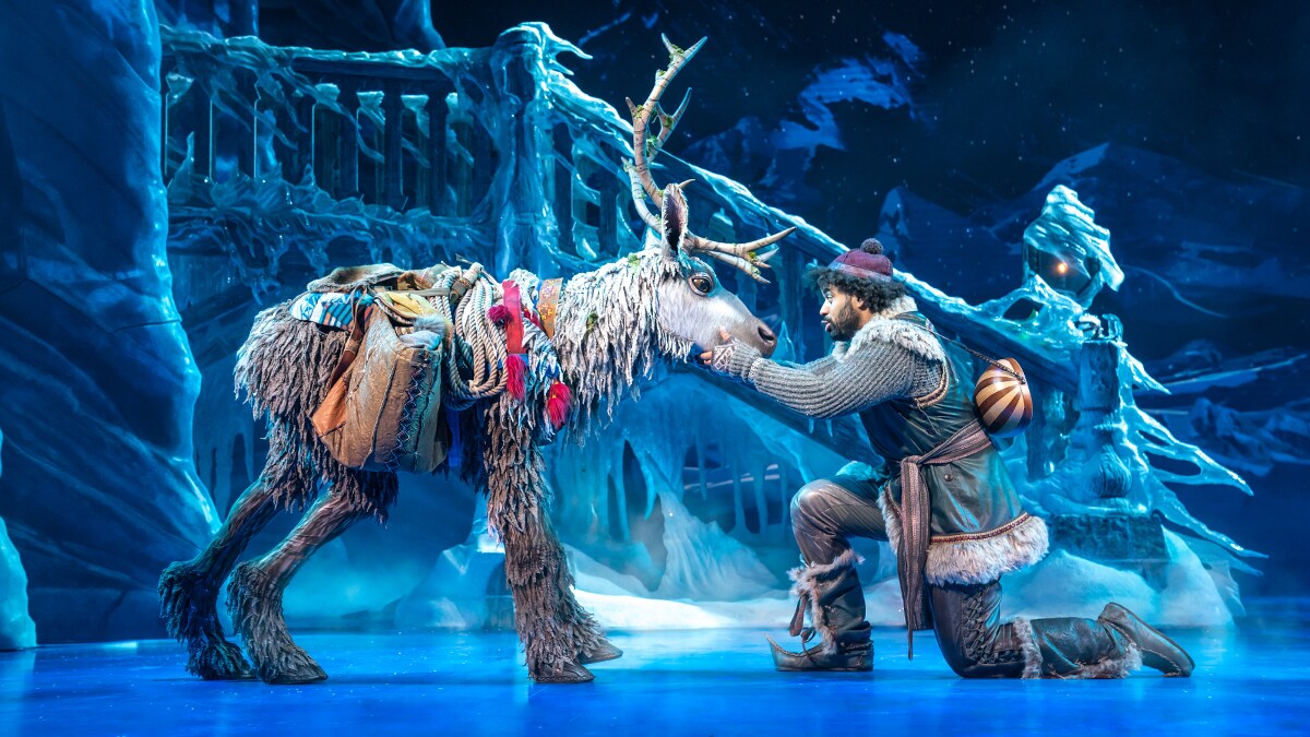 Kristoff holding Sven's face with his hands in front of an ice bridge.
