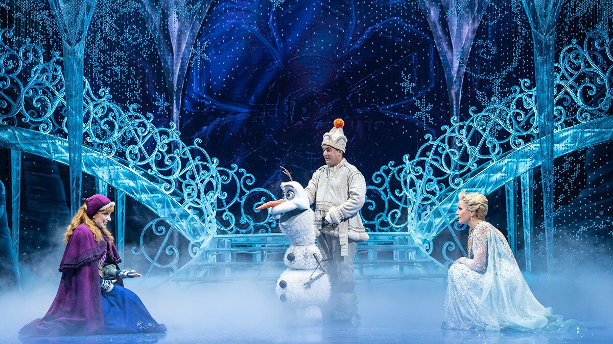 Anna, Olaf and Elsa talking in front of the steps of the ice palace