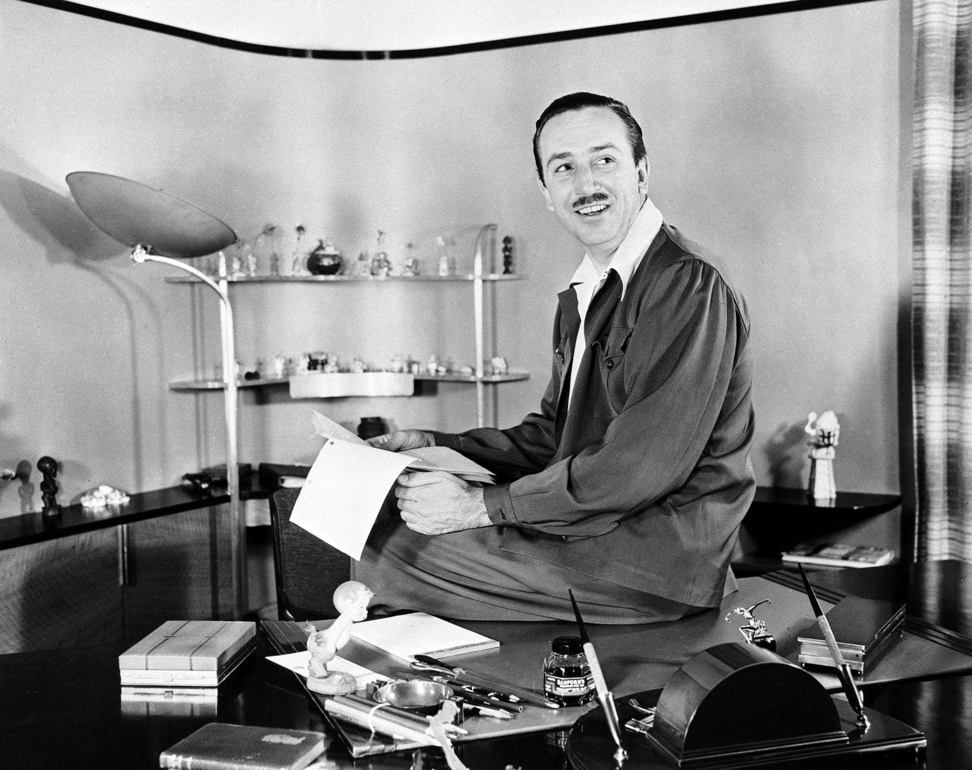 Walt Disney sitting at his desk