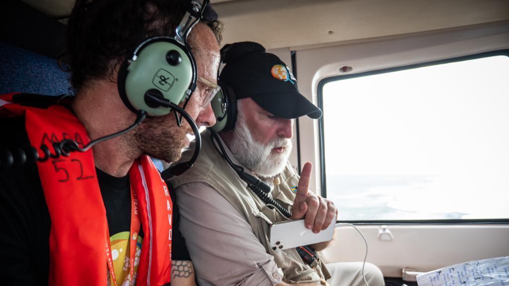 José Andrés (R) and Sam Bloch (L) discuss their written plan on a helicopter flying over Abaco Island, Bahamas. (Credit: National Geographic/Sebastian Lindstrom)