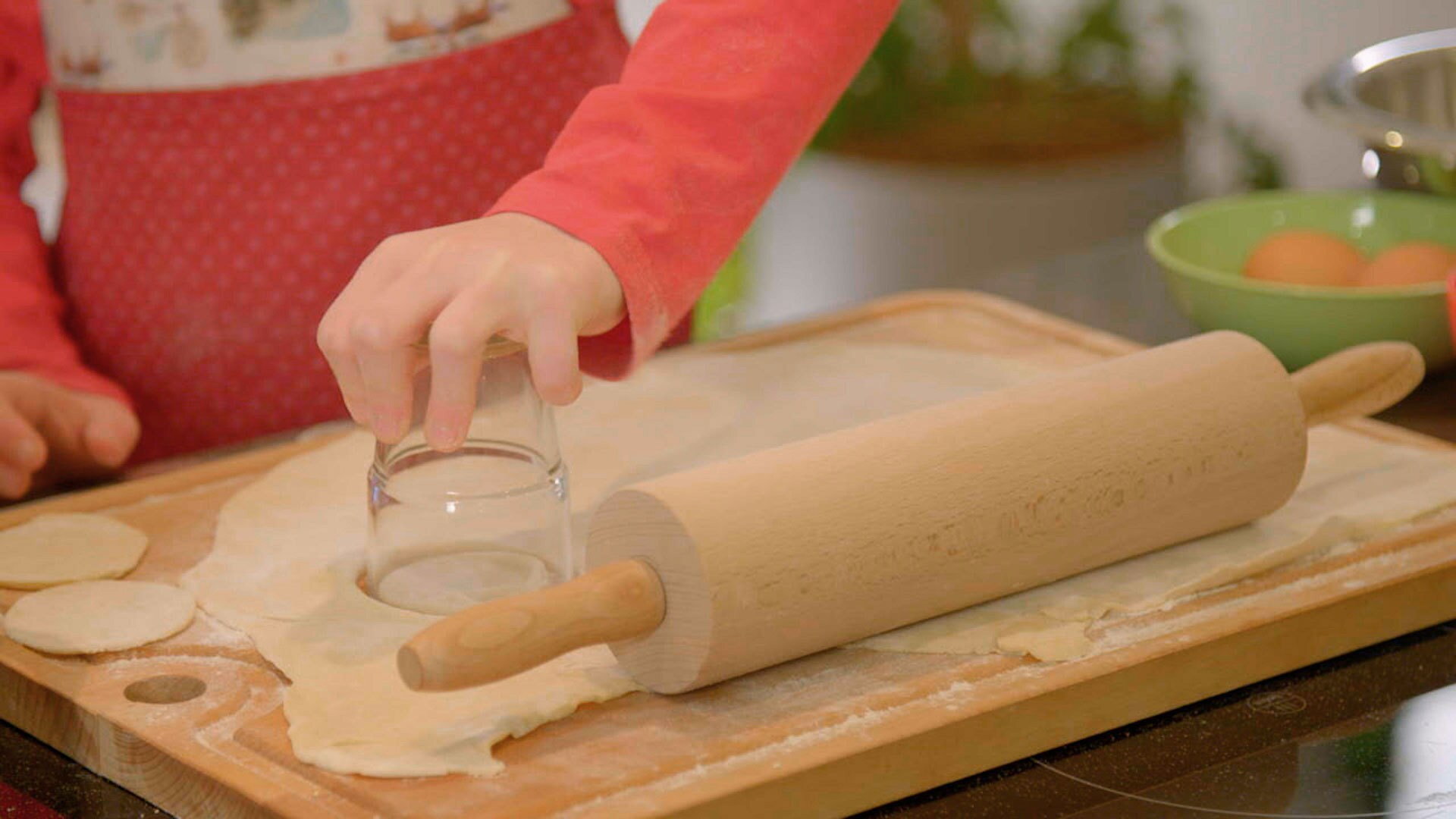 Rolle den Teig aus und steche mit einem Glas runde Teigfladen aus.